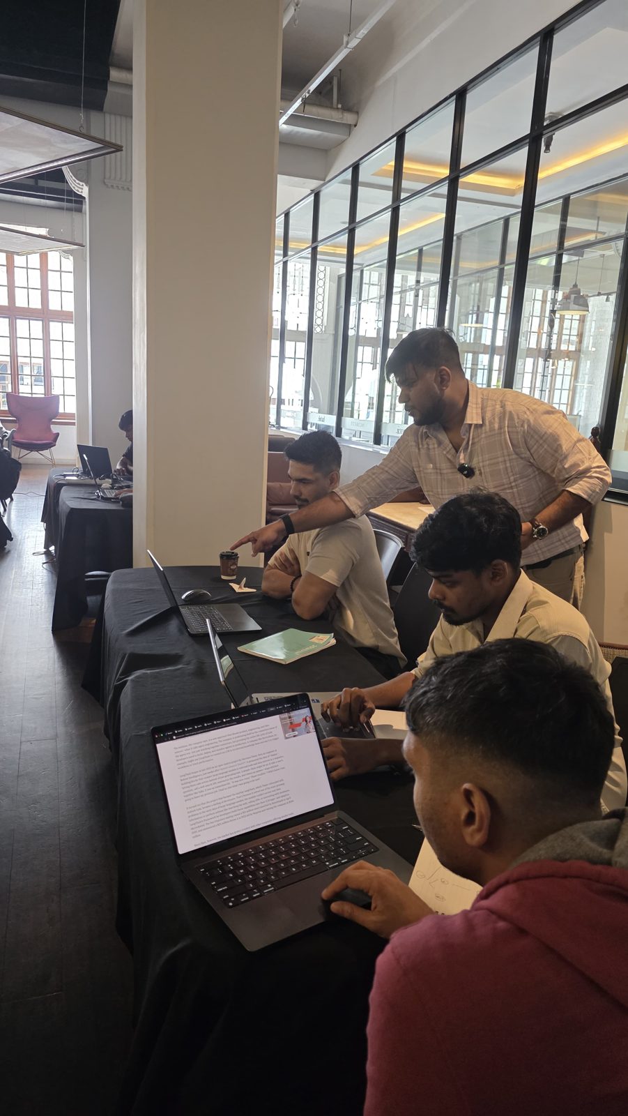 Isuru helping learners build at their laptops
